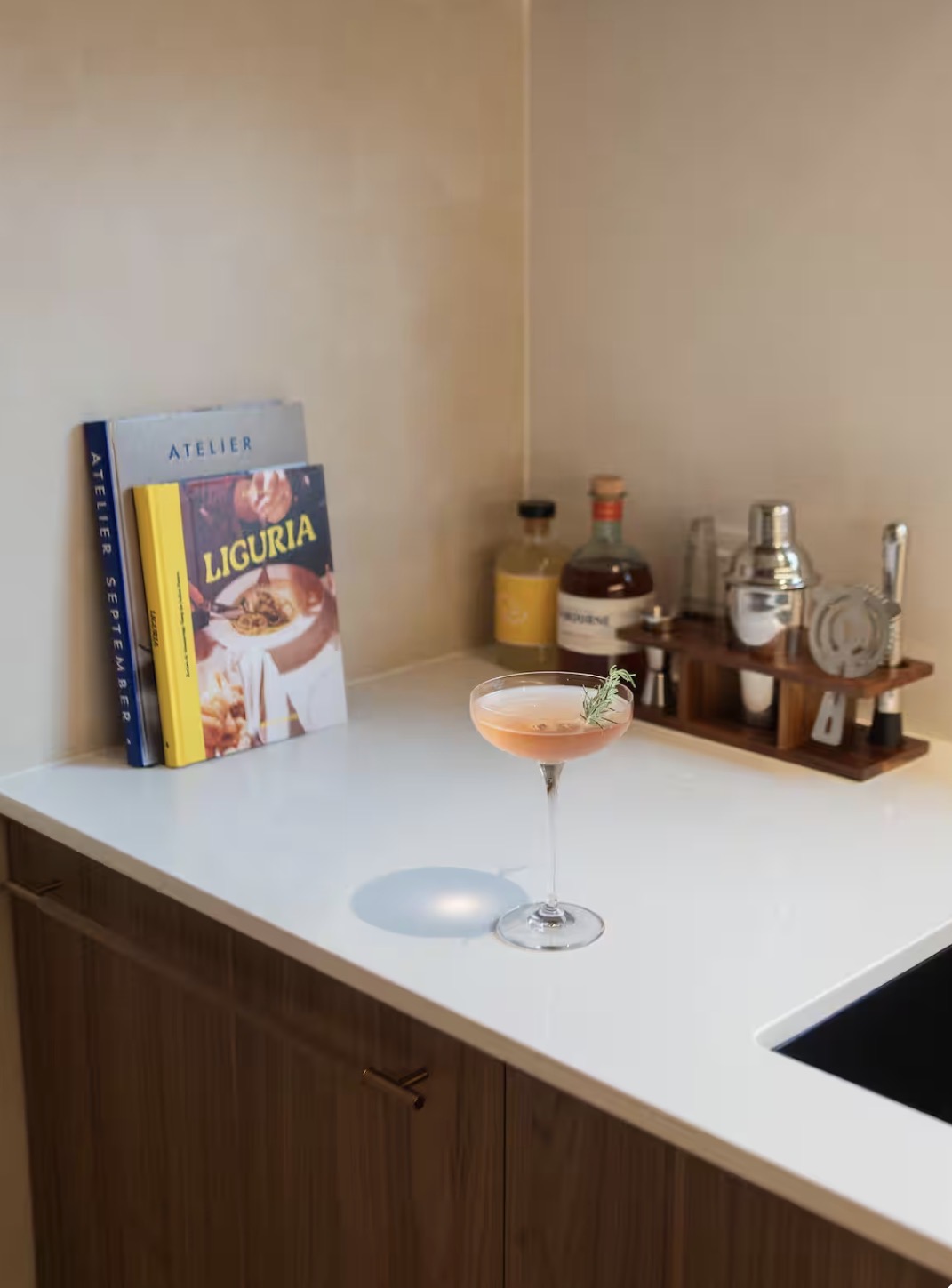 Cocktail on a Belmont Noosa kitchen bench beside cookbooks and bar tools